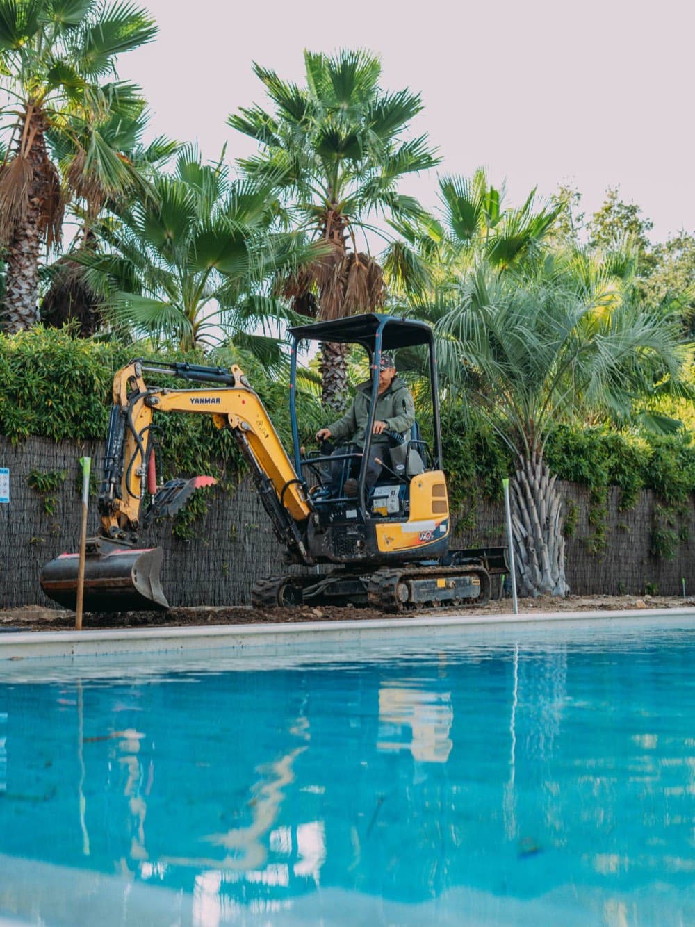 Mini-pelle de BML Paysages au bord de la piscine d’une villa à Ramatuelle