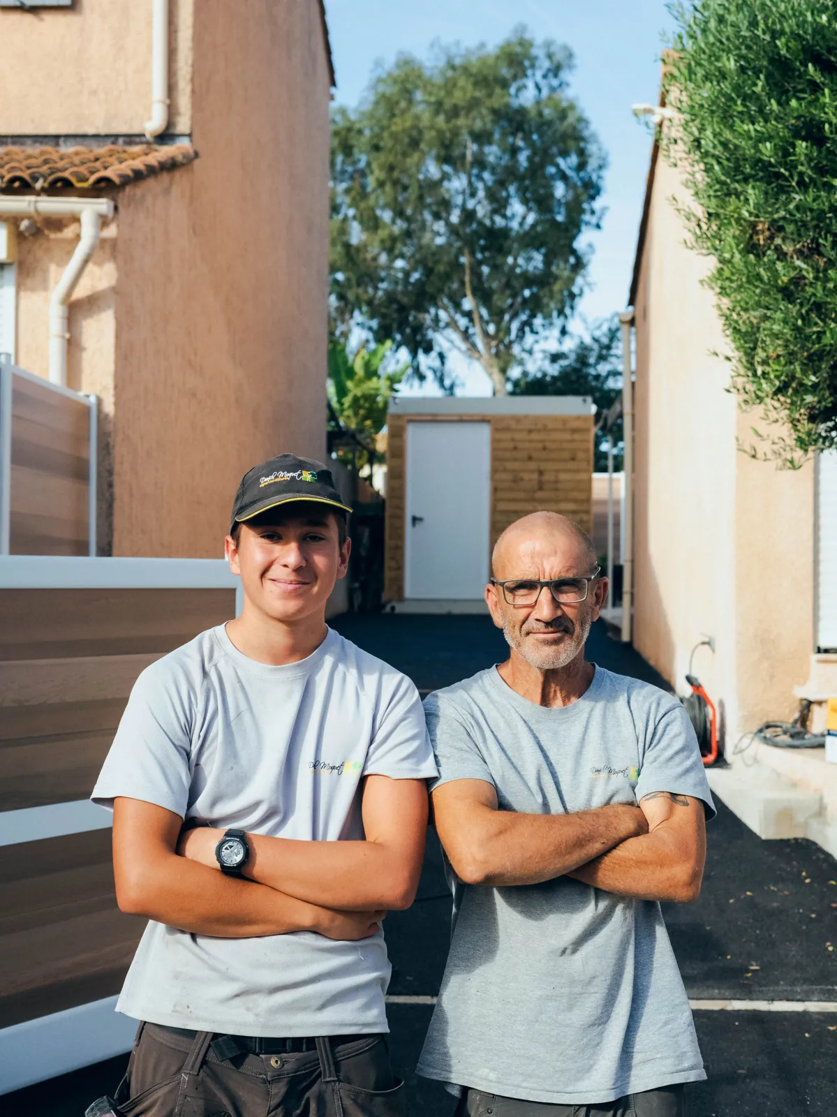 Deux poseurs de l’agence Daniel Moquet de Hyères, bras croisés, sur un chantier de clôture dans le Var