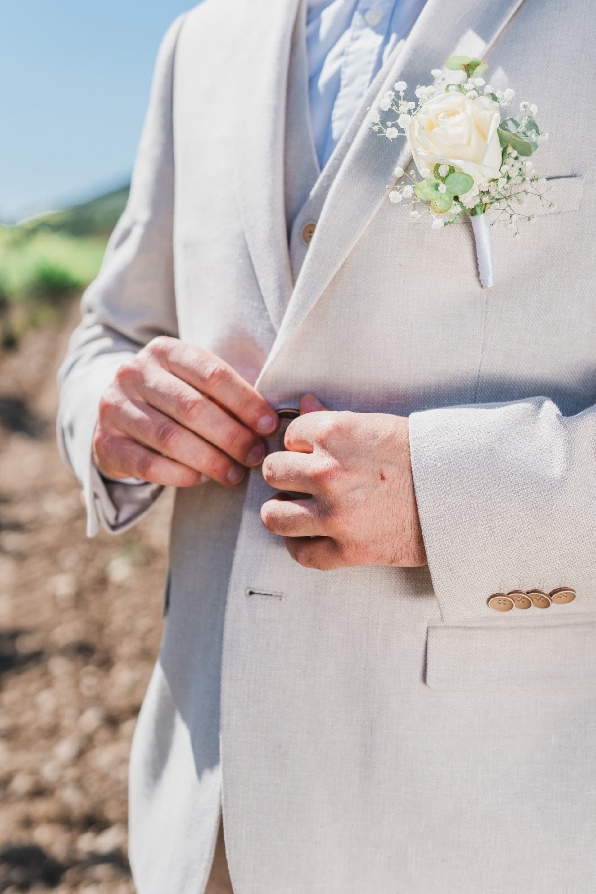 Détail boutonnière marié — rose blanche et veste lin claire, mariage dans le Var par Hugo Bransard