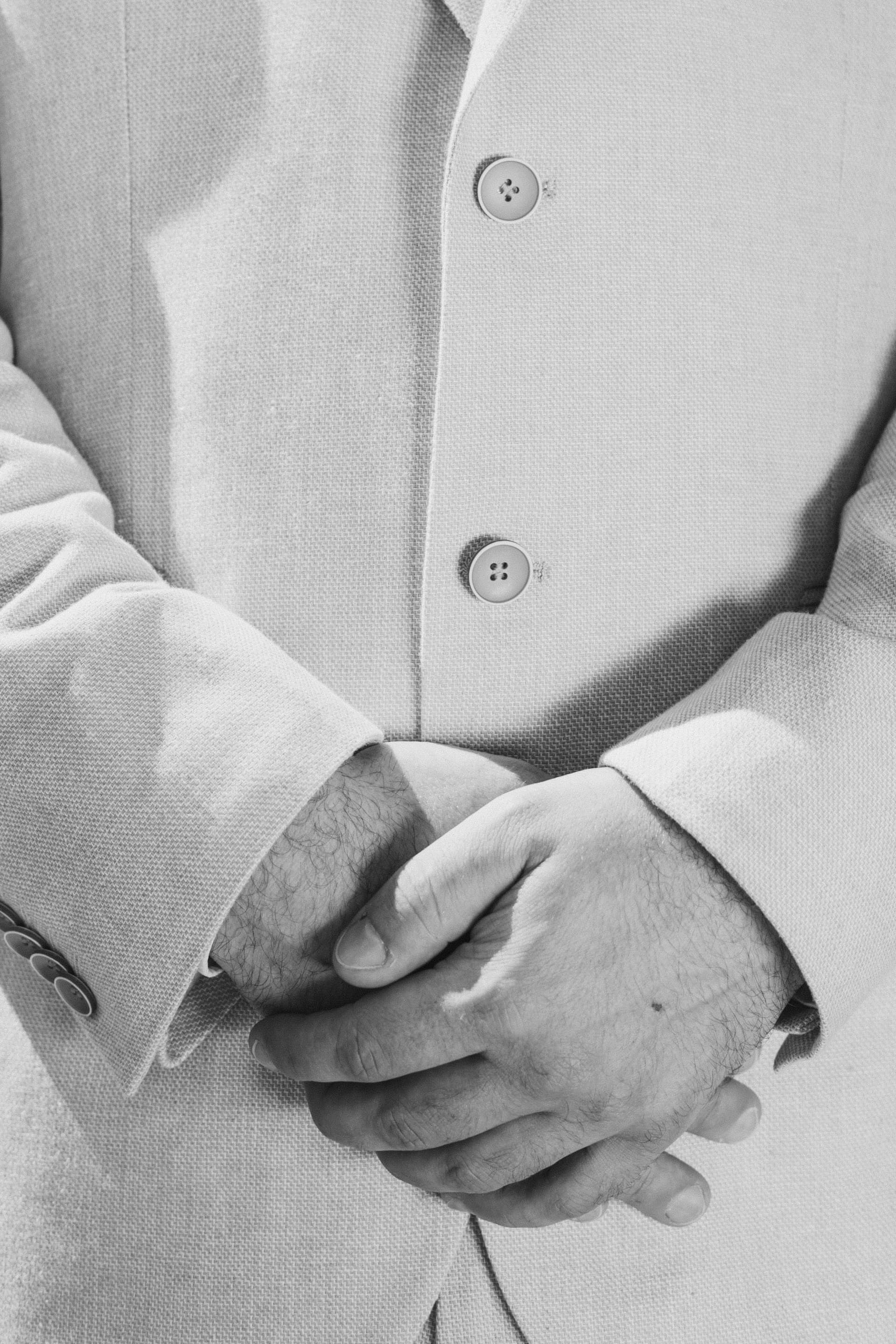 Portrait noir et blanc du marié — détail mains et costume, photographe mariage Var par Hugo Bransard